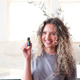 dōTERRA Air Atemwegs-Mischung 15ml – blonde Frau hält Flasche im Wohnzimmer | doTERRA