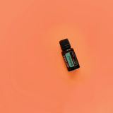 dōTERRA Balance Mischung 15ml – geneigte Flasche von oben, orange-korallenfarbener Hintergrund | doTERRA