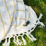 dōTERRA Cheer Mischung 5ml – Flasche auf Leinendecke, beige mit goldenen Fransen und grünen Kräutern | doTERRA