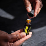 dōTERRA Cheer Mischung 5ml – zwei geöffnete Hände halten Flasche vor dunklem, dramatischem Hintergrund | doTERRA