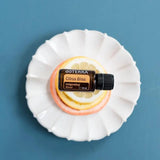 dōTERRA Belebende Mischung (Citrus Bliss) 15ml – weißer Teller mit Zitronen- und Grapefruitsscheiben, blauer Hintergrund von oben | doTERRA