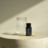 dōTERRA DDR Prime Softgels – Flasche auf Steinsockel neben Wassergefäß im Licht | doTERRA