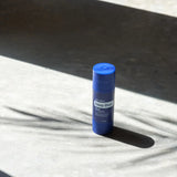 dōTERRA Deep Blue Copaiba Stick auf Steinoberfläche mit Schatten Sonnenlicht | Beruhigungspflege doTERRA