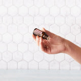 dōTERRA Geraniumöl 15ml Hand Flasche auf weißen Fliesen | dōTERRA Geranium ätherisches Öl