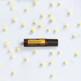 dōTERRA Helichrysum Touch Roll-On 10ml – Flasche auf weißem Keramikteller mit Blumen | doTERRA