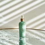 dōTERRA Leave-in Conditioner 237ml Frau mit lockigem Haar im Spiegel | dōTERRA Haarpflege