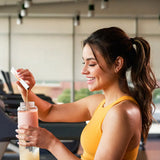 dōTERRA MetaPWR Advantage – Frau im Fitnessstudio mit orangefarbener Flasche | doTERRA