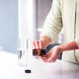 dōTERRA MetaPWR Assist – lächelnde Frau mit Flasche in der Küche | doTERRA