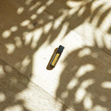dōTERRA MetaPWR Perlen Flasche im Park auf Holz mit Baumschatten und Sonnenlicht Aufsicht | doTERRA