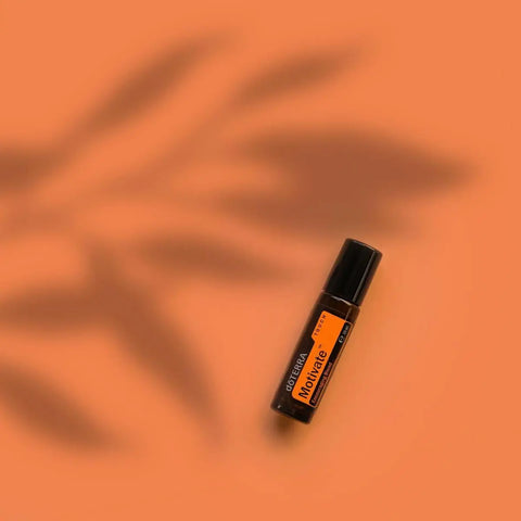 dōTERRA Motivate Touch Roll-on 10ml vor orangem Hintergrund mit Palmenschatten | doTERRA