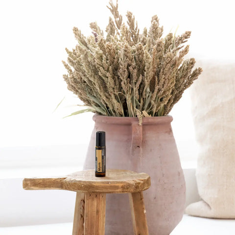 dōTERRA Myrrhe Touch Roll-on 10ml auf rustikalem Holzbank mit Terrakotta-Krug und getrockneten Pflanzen | doTERRA