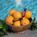 dōTERRA Neroli Touch Roll-on 10ml – zwei Flaschen mit Orangenschüssel am blauen Pool | doTERRA