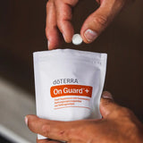 dōTERRA On Guard Plus Kautabletten – Hände halten den Beutel in Nahaufnahme | doTERRA