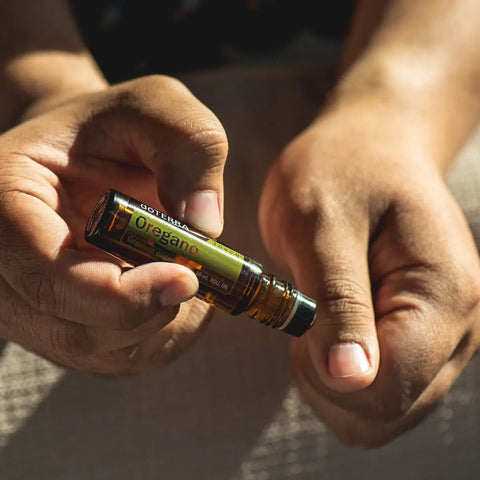 dōTERRA Oregano Touch Roll-on 10ml – anwendende Hände auf warmer Haut im Sonnenlicht | doTERRA