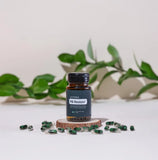 dōTERRA PB Restore – Flasche auf Holzscheibe mit grünen Blättern und Kapseln | doTERRA