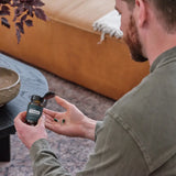 dōTERRA PB Restore – Bärtiger Mann auf Ledersofa mit Flasche und Kapseln (V2) | doTERRA