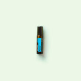 dōTERRA Peace Touch Roll-on 10ml vor grünem Hintergrund mit Minze minimalistisch | doTERRA