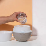 dōTERRA Petal Clean Diffuser Hand füllt Wasser orangener Hintergrund | dōTERRA Diffuser