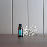 dōTERRA Supermint Öl 15ml auf grauem Schiefer weiße Blumen | dōTERRA Supermint ätherisches Öl