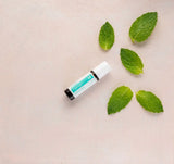 dōTERRA Tamer Roll-On 10ml diagonal auf altrosa mit Blättern und Minze | doTERRA