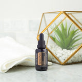 dōTERRA Yarrow Pom 30ml auf Marmor mit weißem Handtuch, geometrischem Terrarium und Gold | doTERRA