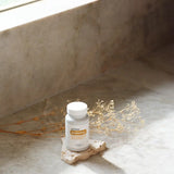 dōTERRA Zendocrine Komplex 60ct weiße Flasche auf Stein mit getrockneten Zweigen | doTERRA