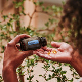 dōTERRA ZenGest Softgels gießend auf Handfläche im Freien | doTERRA