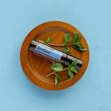 dōTERRA ZenGest Touch Roll-On 10ml auf Holzteller mit Minze vor blauem Hintergrund | doTERRA