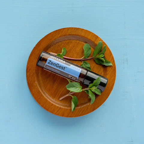 dōTERRA ZenGest Touch Roll-On 10ml auf Holzteller mit Minze vor blauem Hintergrund | doTERRA